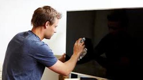 Person cleaning a television